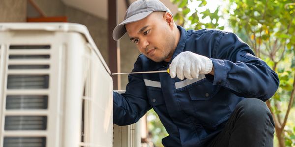 Technician taking apart an AC unit to clean it.